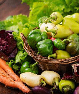 Assortment of vegetables and green herbs. Market. Vegetables in a basket on a dark background