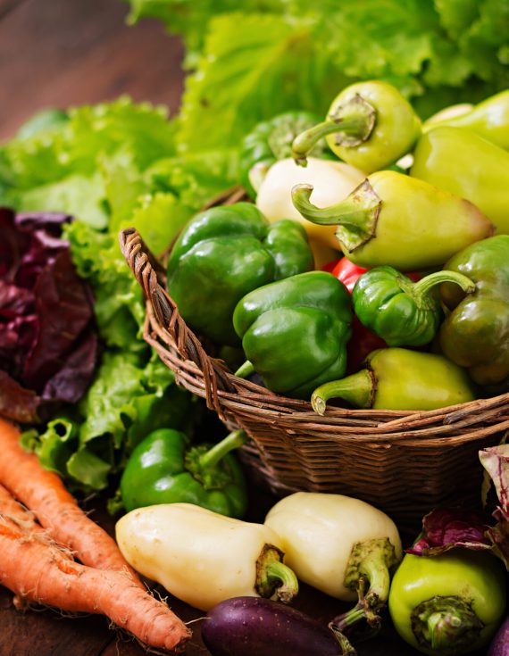 Assortment of vegetables and green herbs. Market. Vegetables in a basket on a dark background